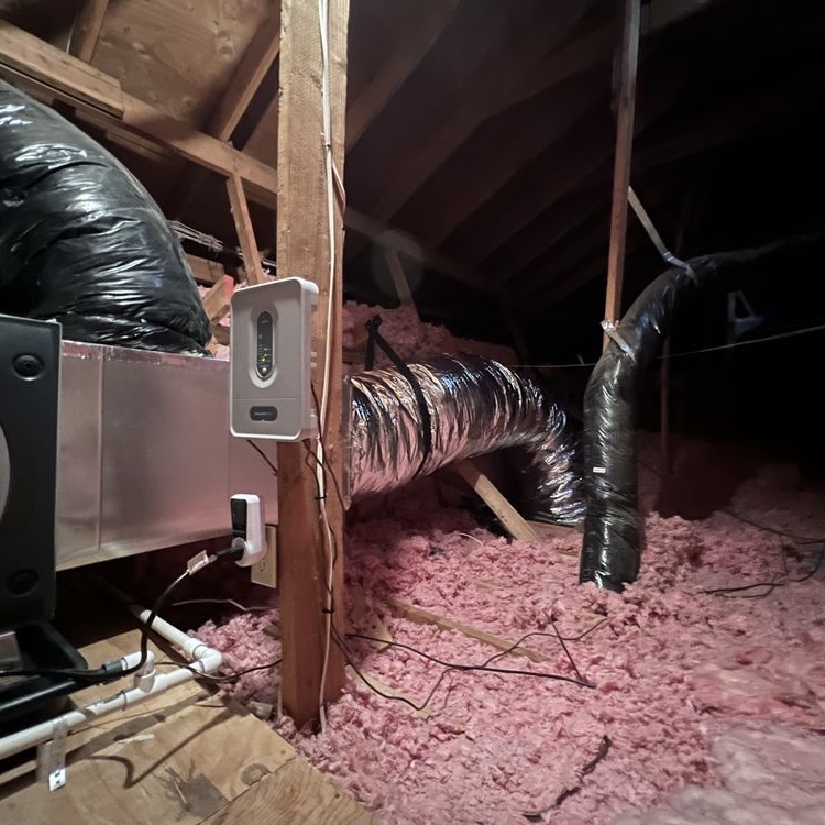 Attic air handler installation with ecobee smart thermostat and pink insulation