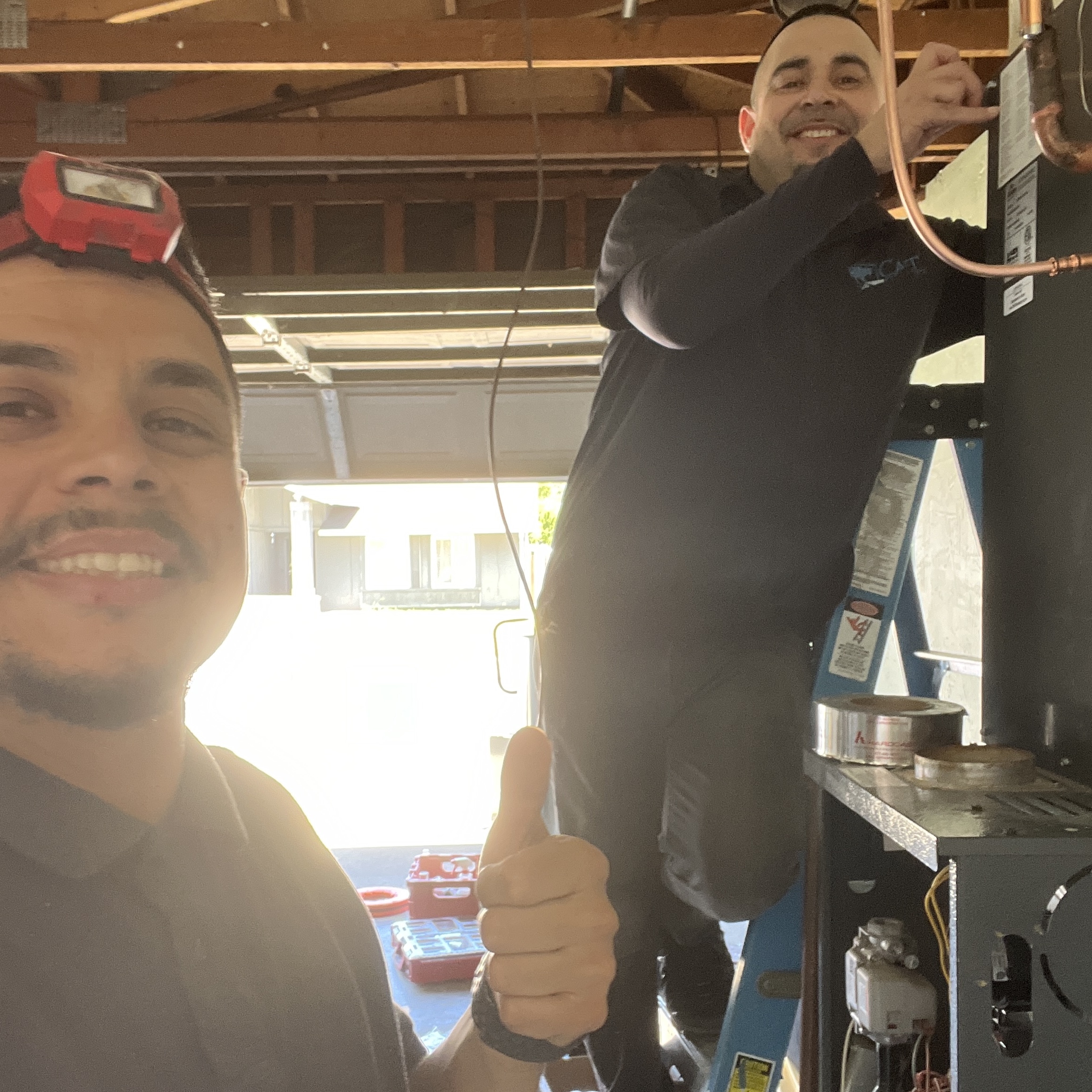 Comfortable HVAC Services team completing furnace installation in residential garage