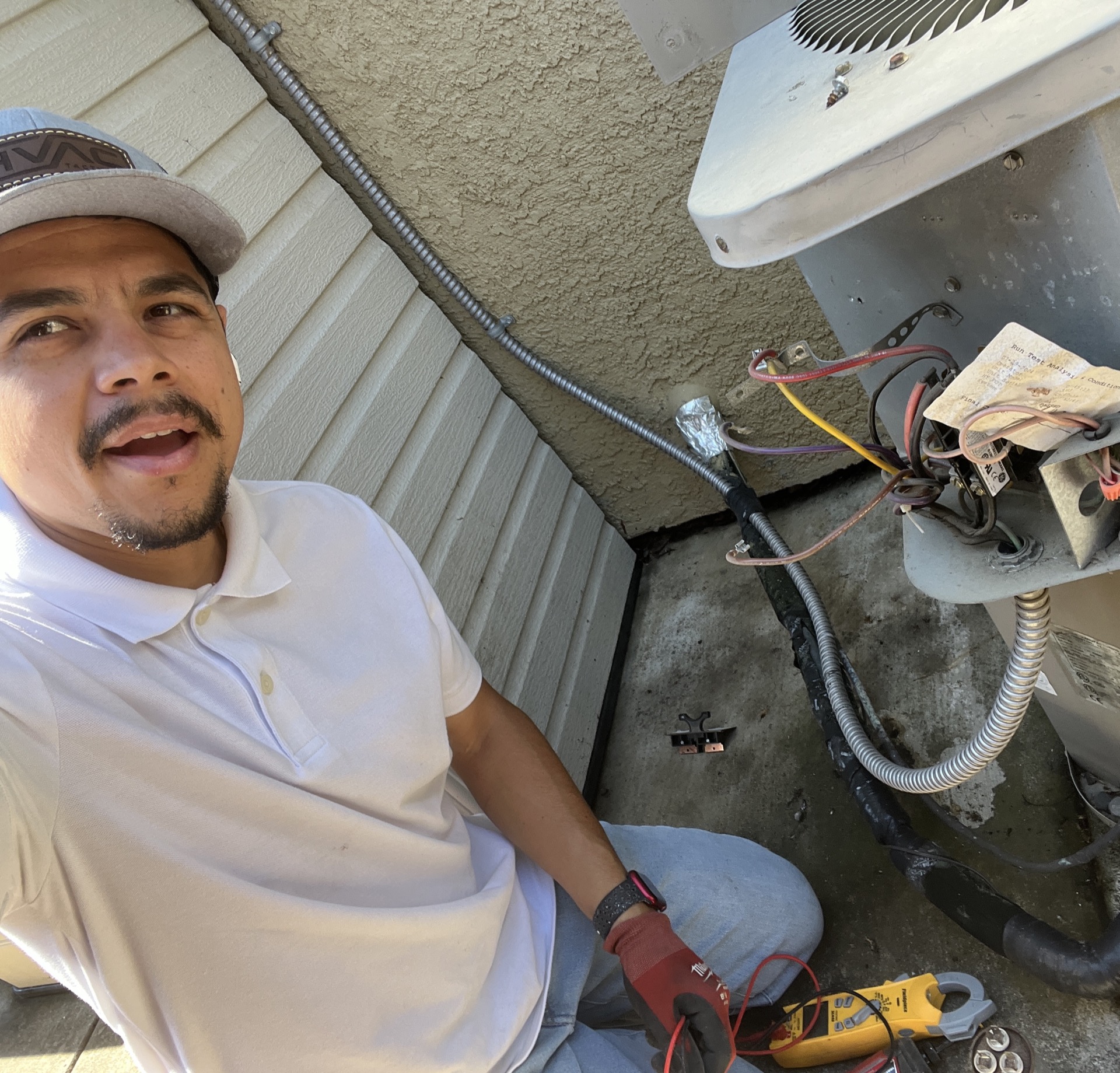 HVAC technician repairing AC condenser electrical connections and wiring