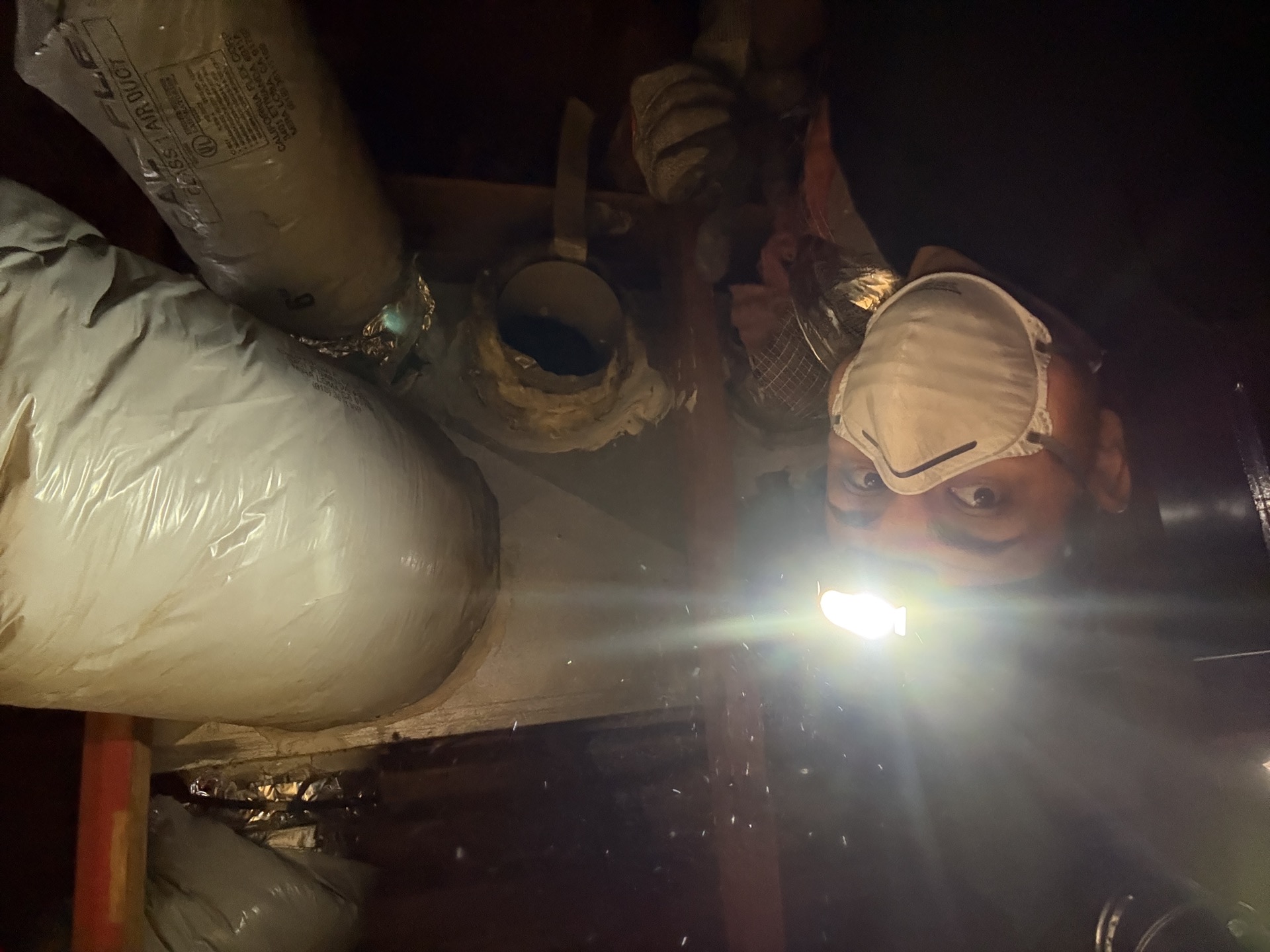 HVAC technician installing ductwork in tight attic space in Rancho Cordova