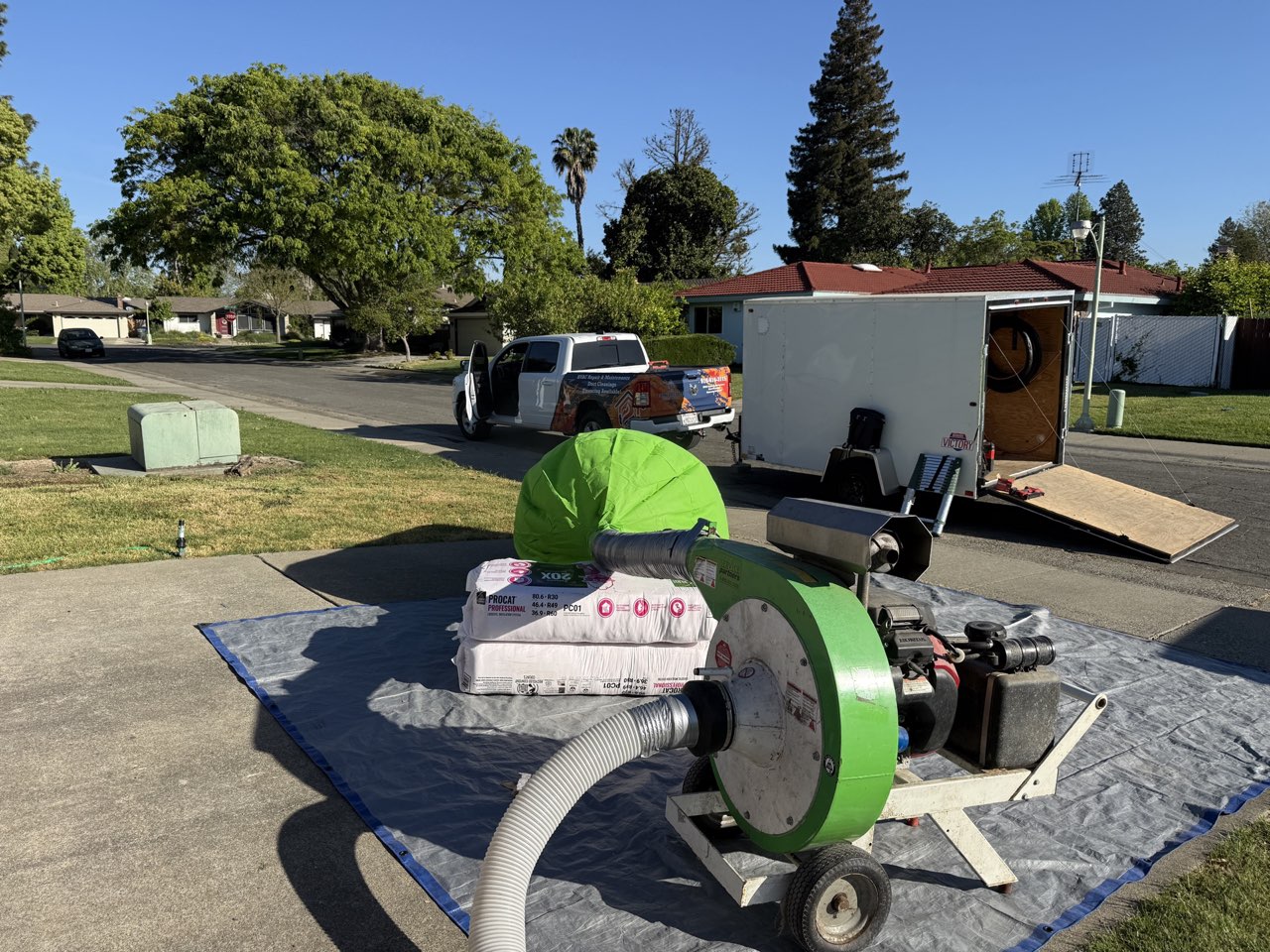 Comfortable HVAC Services truck and insulation blower machine set up for attic insulation job