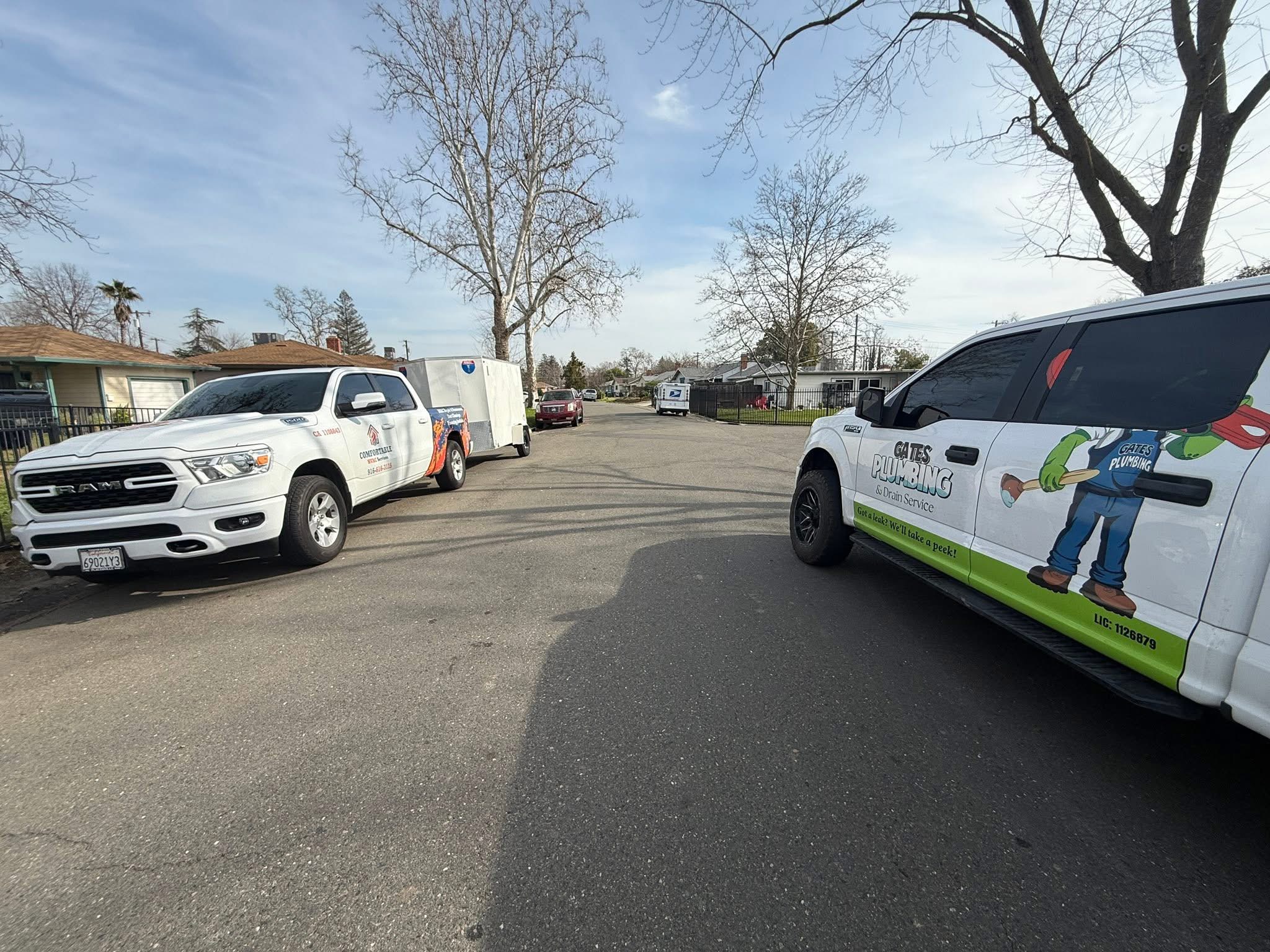 Comfortable HVAC Services and Gates Plumbing & Drain Service trucks parked on a Sacramento street